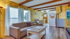 A cozy room with a sofa, a coffee table, and a dining area with chairs and a table.