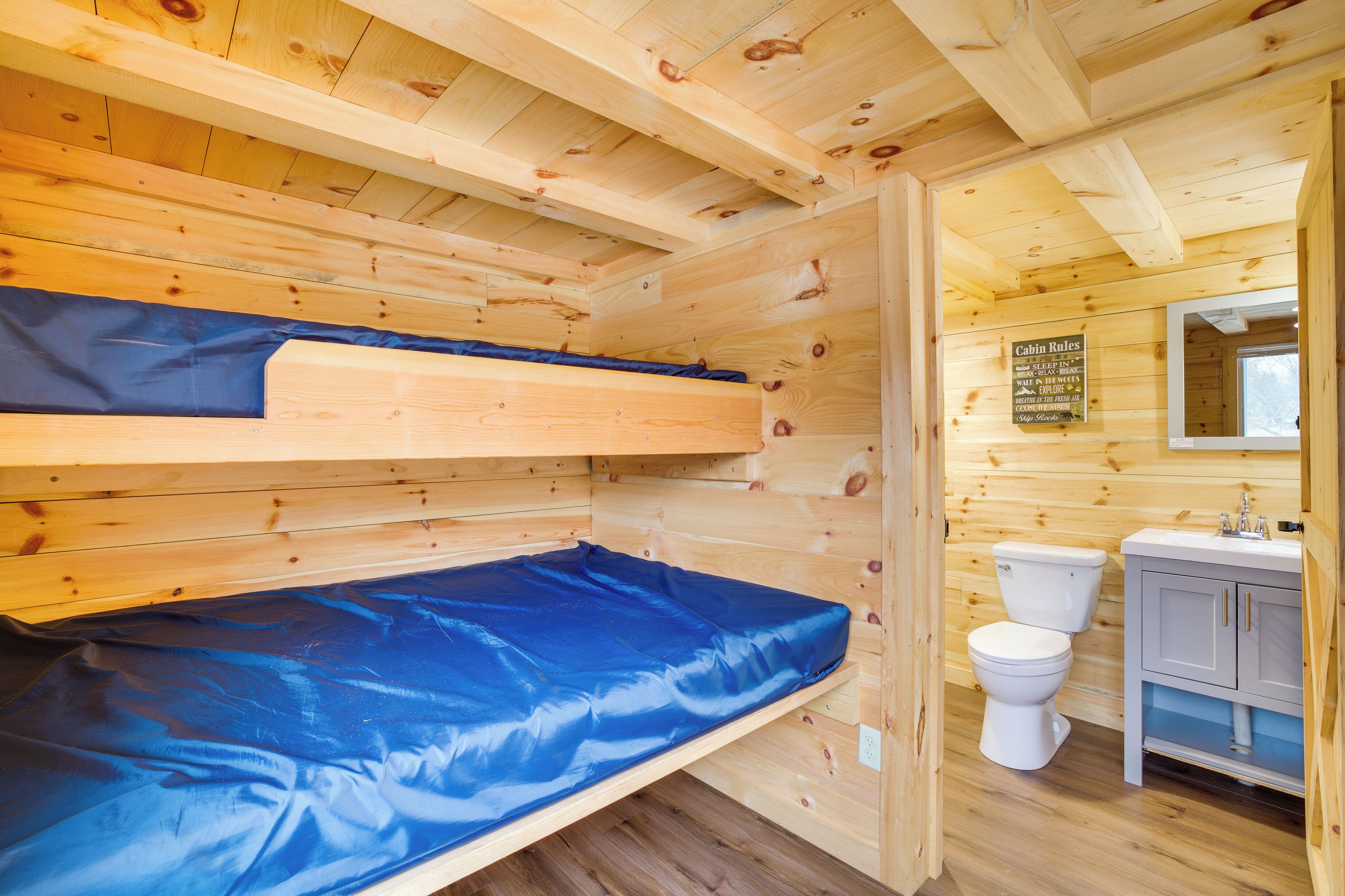 Una cabana amb un llit superposat, un vàter i un rentapla.