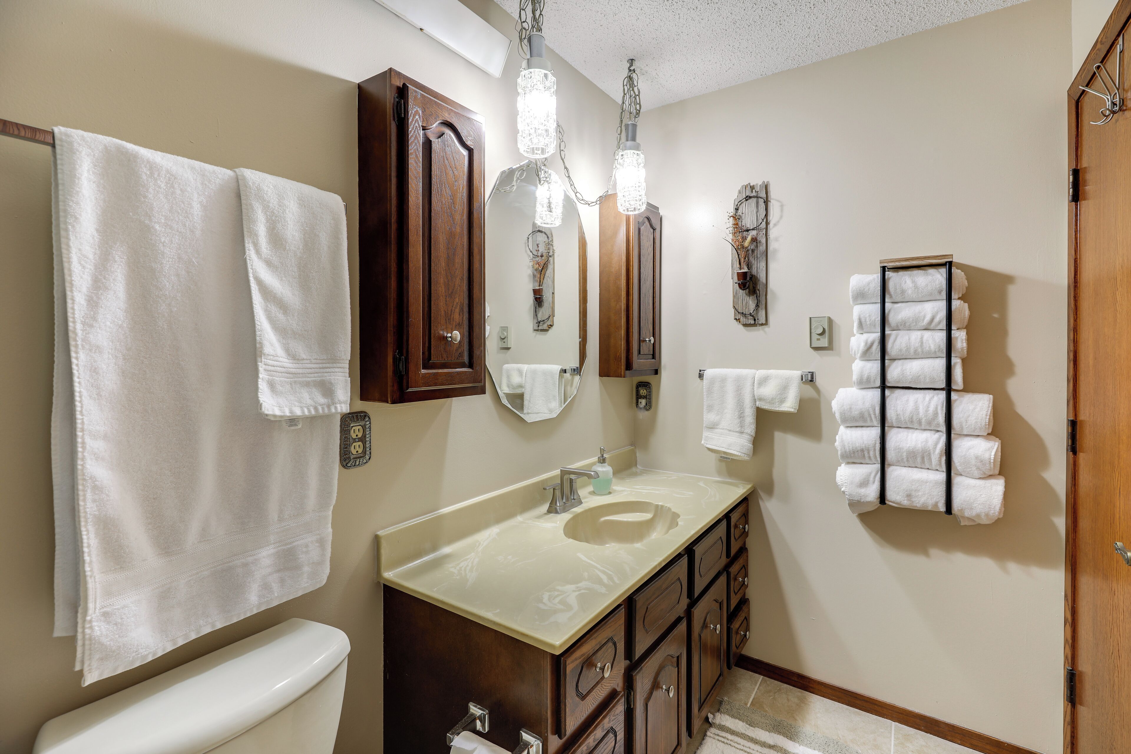 A bathroom with a toilet, sink, and towel rack.