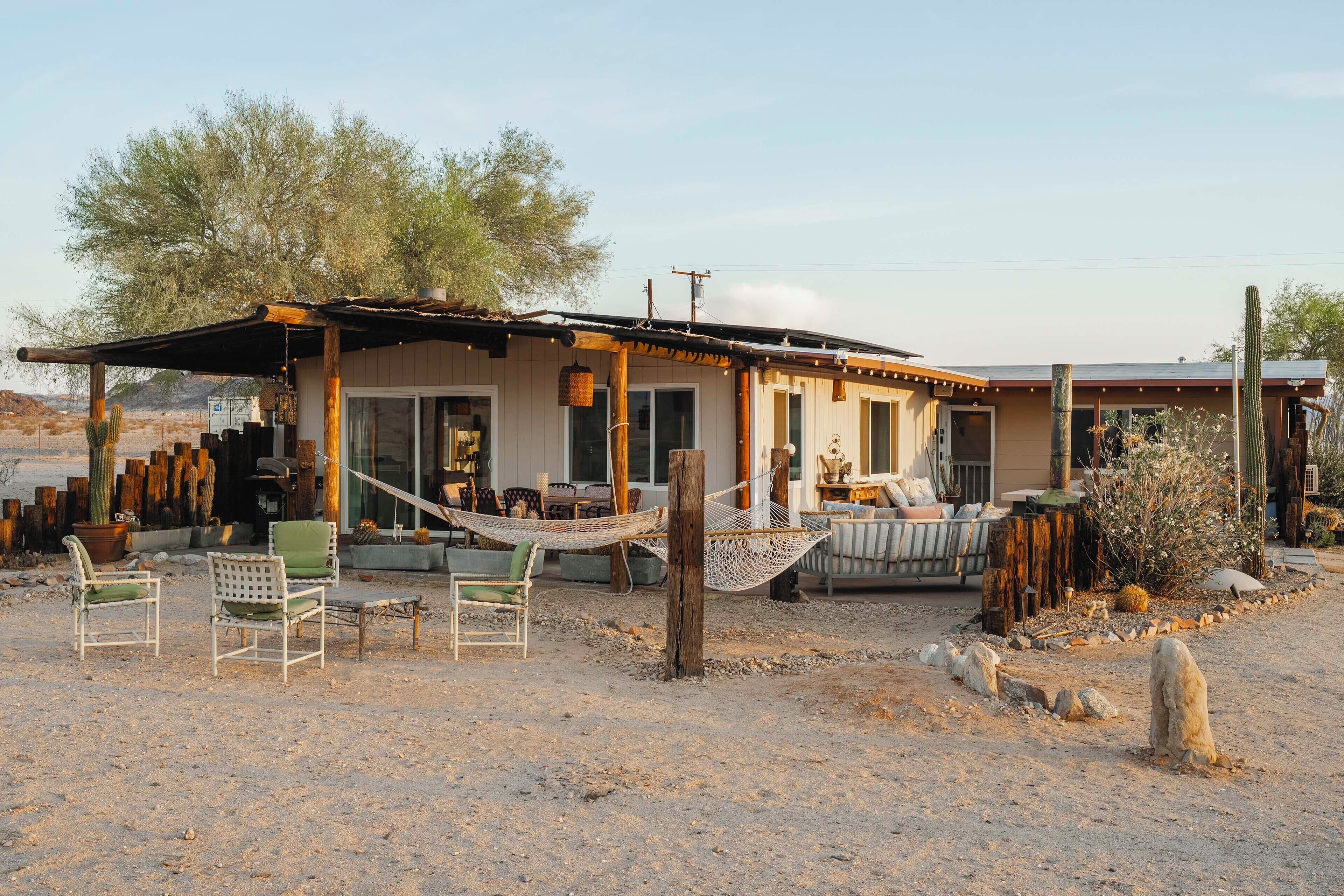 A rustic building with a porch, outdoor seating, and a hammock.