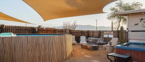 A backyard with a pool, outdoor seating, and a hot tub.