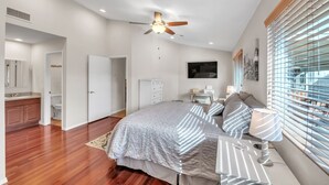 A bedroom with a bed, bedside table, lamp, and a ceiling fan. - Summer All Year Round 2 Bedroom Home by RedAwning (Phoenix)