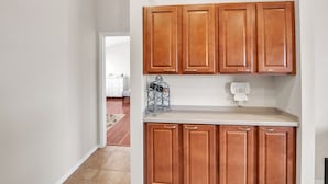 A kitchen with wooden cabinets, a countertop, and a wine rack. - Summer All Year Round 2 Bedroom Home by RedAwning (Phoenix)