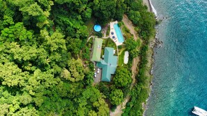 An aerial view of a coastal property with a swimming pool, a covered patio, and lush greenery. - Authentic St. Lucian Experience At Prestigious 2-bed Villa - Colibri Cottage 2 Bedroom Villa by RedAwning (Soufrière)