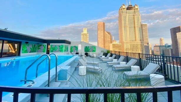 A rooftop pool area with lounge chairs and a city skyline view. - Luxury Designer Penthouse 3801 | Pool | Gold Coast (Chicago)