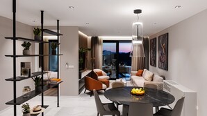 Een moderne woonkamer met een eethoek, met een zwart marmeren tafel, strakke meubels en uitzicht op de bergen door grote ramen.