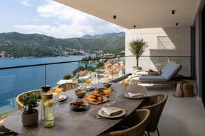 Comedor con una mesa lista para el desayuno, con vista a un lago y montañas pintorescos.