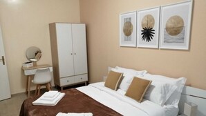 Une chambre d’hôtel avec un lit, un bureau, une armoire et des œuvres d’art accrochées au mur.