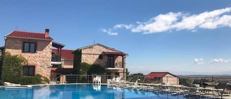 Una piscina al aire libre de temporada, sombrillas
