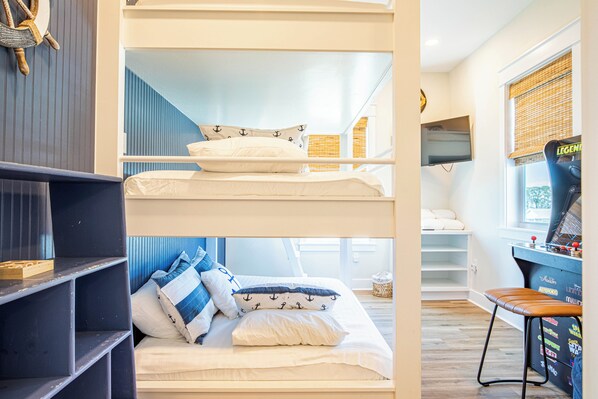 A bunk bed with a desk and chair, a television, and a window with blinds. - Gulf front with a private pool. (Port St Joe)
