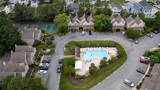 Zona residencial amb piscina, pistes de tenis i cases.