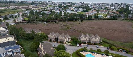 A residential area with houses, a swimming pool, and a view of the sea.