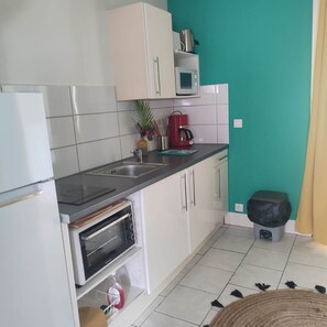 Cozinha equipada com micro-ondas, cafeteira e forno elétrico.