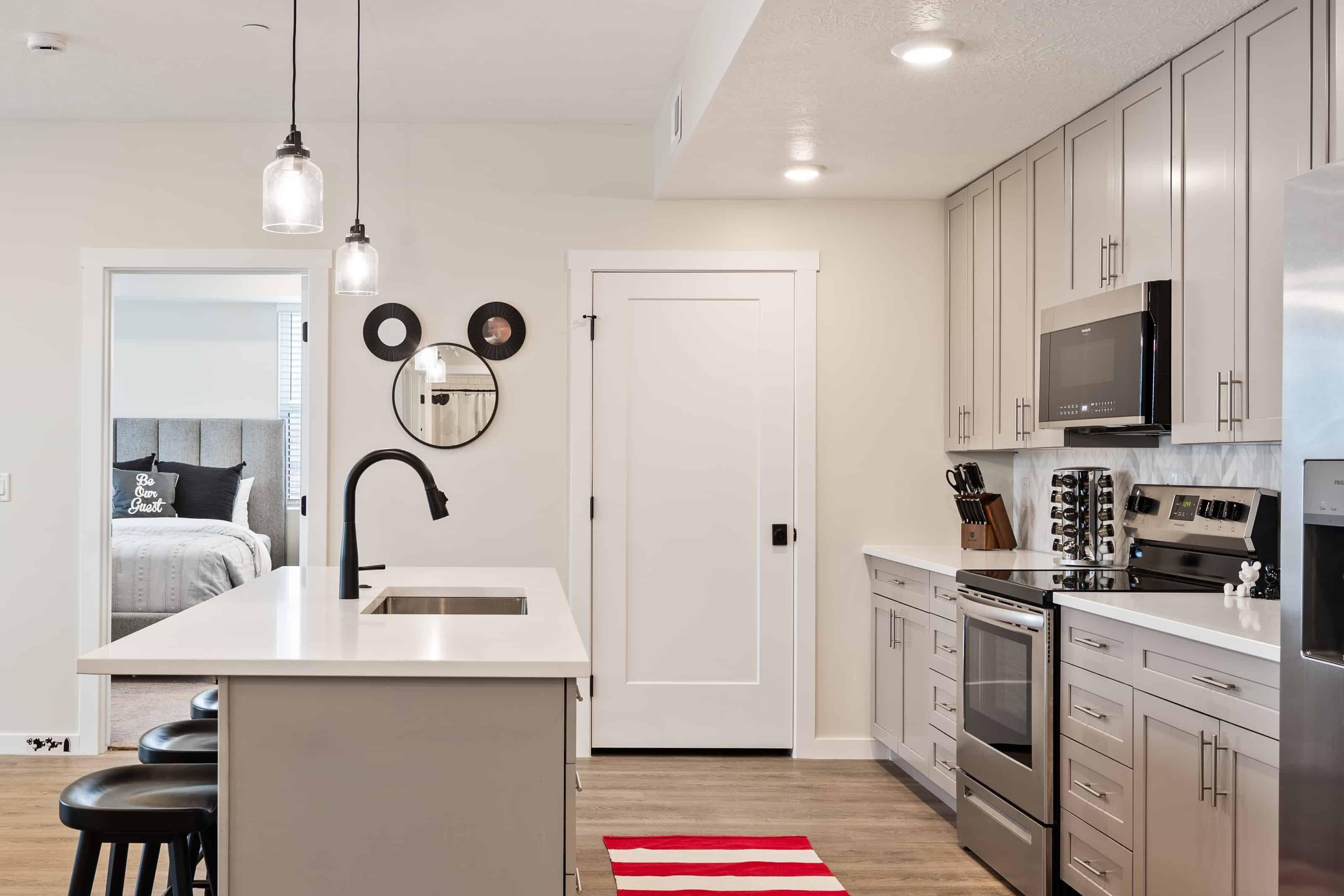A modern kitchen with a central island, stainless steel appliances, and a white countertop.