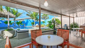 Un patio exterior con piscina, muebles de madera y plantas en macetas.