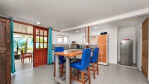 Una cocina moderna con una mesa de madera y sillas azules, un refrigerador y un microondas.