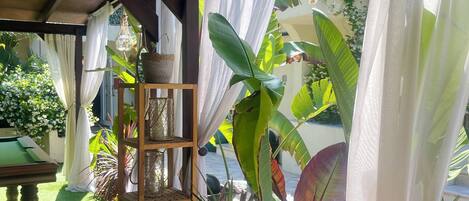 A cozy room with a pool table, wooden furniture, and lush green plants.