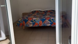 Ein Schlafzimmer mit Bett, Tür und Fenster.