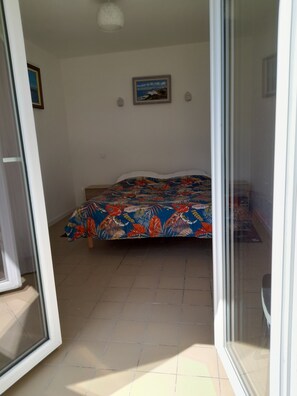 Ein Schlafzimmer mit Bett, Tür und Fenster.