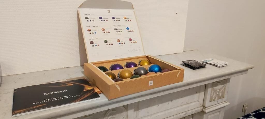 A wooden box with colorful balls, a brochure, and a calculator on a marble surface.