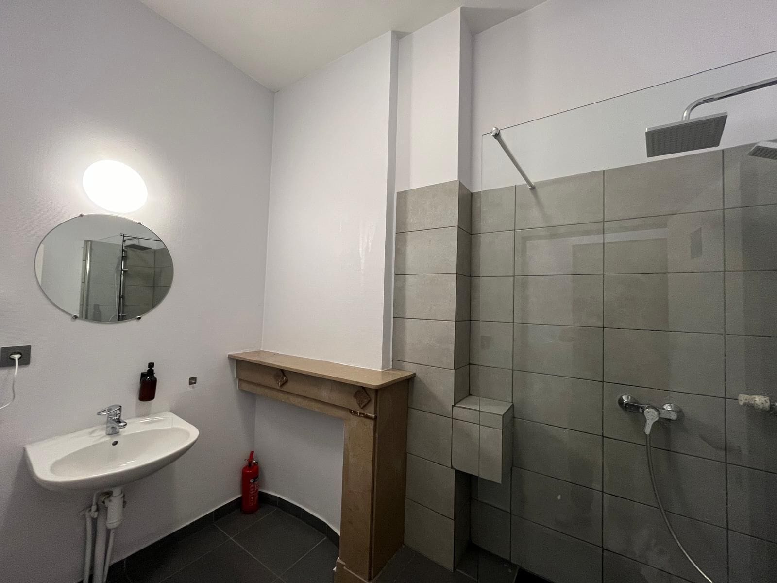 A modern bathroom with a sink, mirror, and shower.