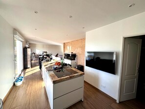 Una cocina moderna con una isla grande, electrodomésticos integrados y un comedor con vistas.