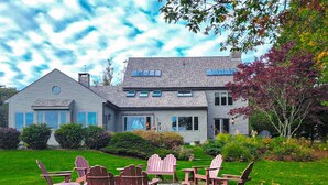 A house with a well-maintained lawn and outdoor seating area. - Experience coastal charm at Tidewatch in Boothbay, a spacious 3-bedroom home near the ocean. (Boothbay)