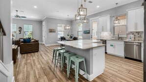 A modern kitchen with a central island, bar stools, and stainless steel appliances. - 🌴 Sea Ya Sun 4BR | FAB Kitchen • 2 Pools • Miramar Beach 🏖️ (Miramar Beach)
