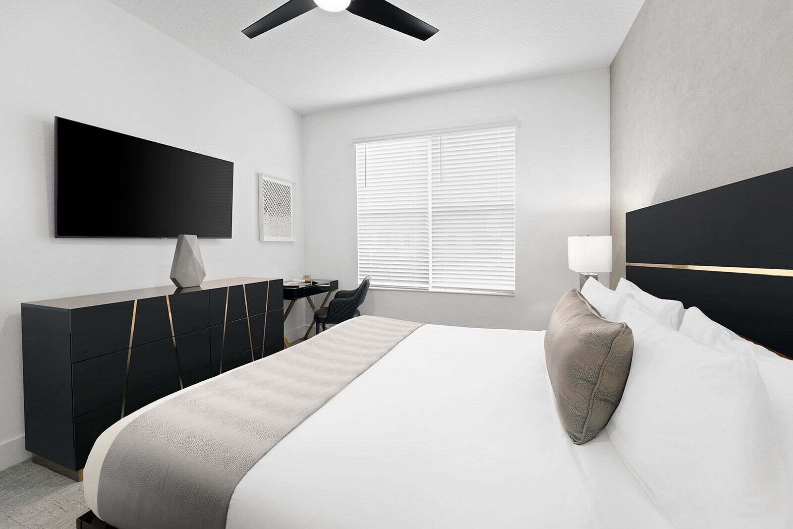 A modern bedroom with a bed, a desk, a chair, a TV, and a window with blinds.