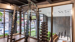 A gym with exercise equipment, large windows, and a view of the street outside. - B.Homy - Be Urban Brooklin (São Paulo)