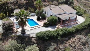 A single-story house with a swimming pool, surrounded by vegetation and other houses in a hilly area. - Beautiful Casa Jade, 3 Bedroom. Private,secluded pool & gardens. Mountain Views  (AN)