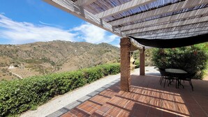 A patio with a view of a hilly landscape, a brick column, and a table with chairs. - Beautiful Casa Jade, 3 Bedroom. Private,secluded pool & gardens. Mountain Views  (AN)