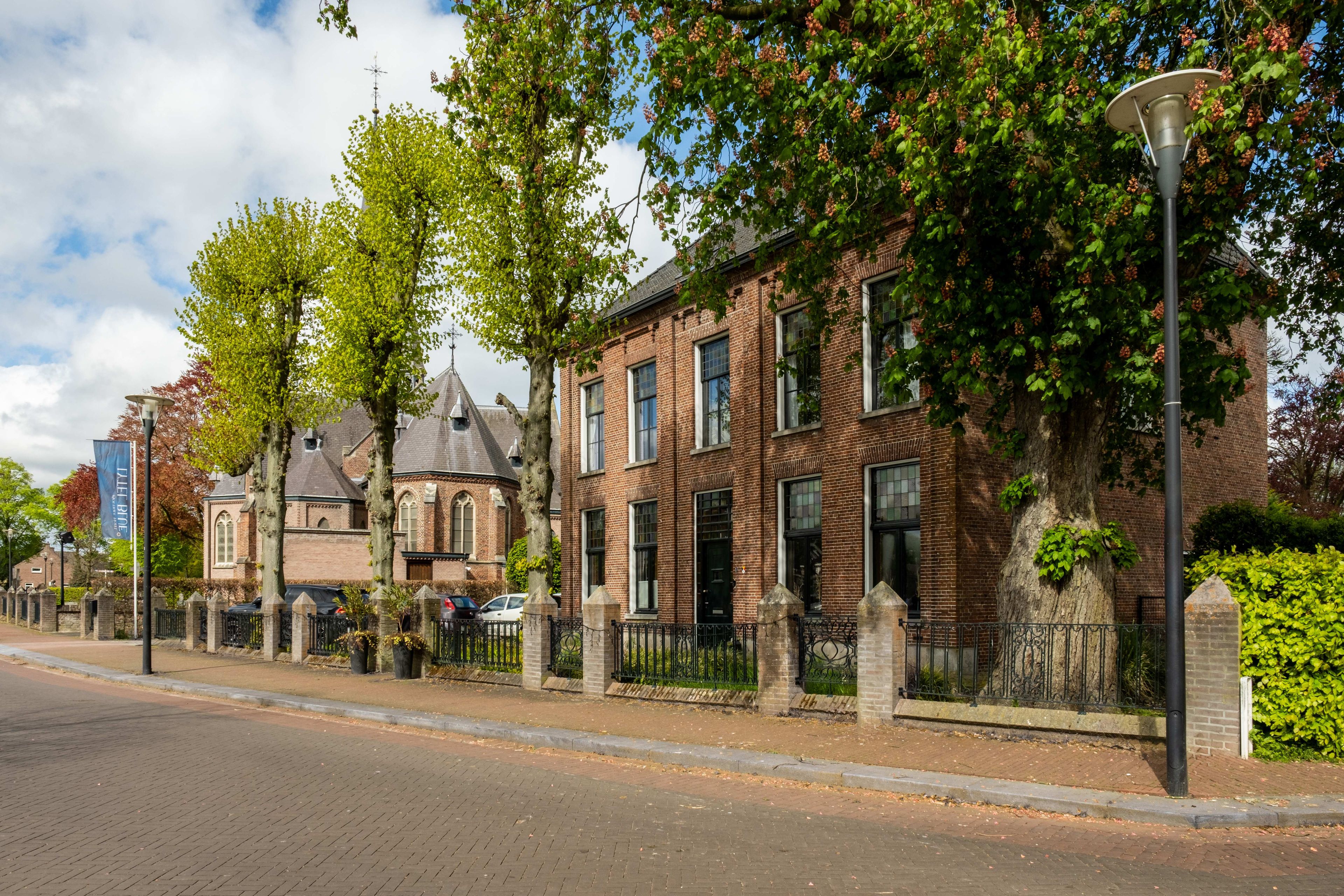 Eine Straße mit Backsteingebäuden, einem Laternenpfahl und blauem Himmel.