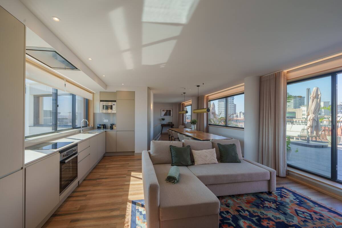 A modern apartment with a kitchen, dining area, and living room.