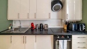 A compact kitchen with a sink, a coffee maker, a toaster, and a microwave. - [Covent Garden-Fitzrovia]Central London Apartment (London)