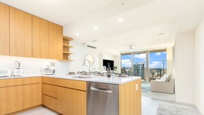 A modern kitchen with wooden cabinets, a stainless steel dishwasher, and a large island.