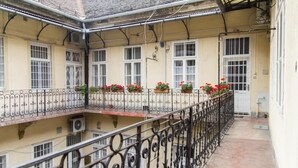 A multi-story building with balconies, each with wrought iron railings and flower boxes. - Lovely Apartment by National Museum (Budapest)