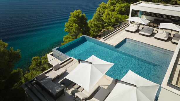 A pool with a view of the sea, surrounded by lounge chairs and umbrellas. - Villa Mirabel, VILLA MIRABEL 5* (Mimice)