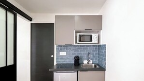 Une cuisine compacte équipée d’un four à micro-ondes, d’un évier et d’un lave-vaisselle.