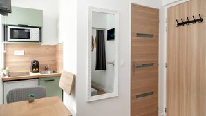 Una cocina compacta equipada con microondas, lavamanos y un pequeño comedor.