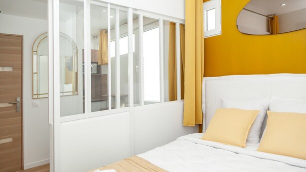 Een slaapkamer met een bed, een kledingkast en een spiegel.
