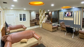 A spacious living area with leather sofas, a coffee table, and a television. - Hotel Diva (Istanbul)