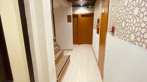 A hallway with a wooden staircase, a patterned wall, and a ceiling with recessed lighting. - Hotel Diva (Istanbul)