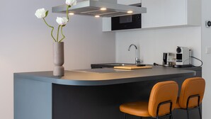 A modern kitchen with a central island, a built-in oven, and a coffee machine. - The Doorman Goethe  (Frankfurt)