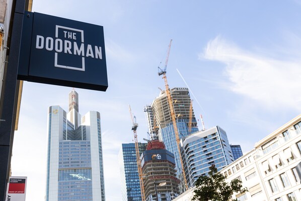 A cityscape with a prominent sign for "The Doorman" hotel. - The Doorman Goethe  (Frankfurt)
