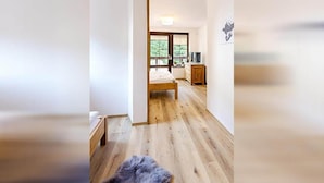 A room with a wooden floor, a bed, a dresser, and a television. - Harrachov Lhje261 in Harrachov (Harrachov)