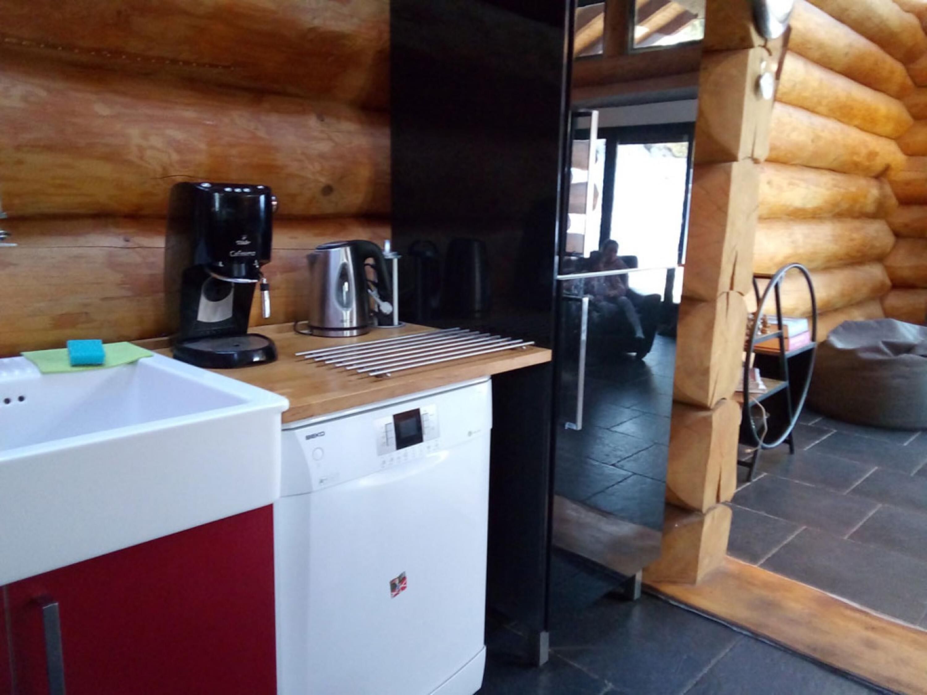 A compact kitchen with a coffee maker, kettle, and a sink.