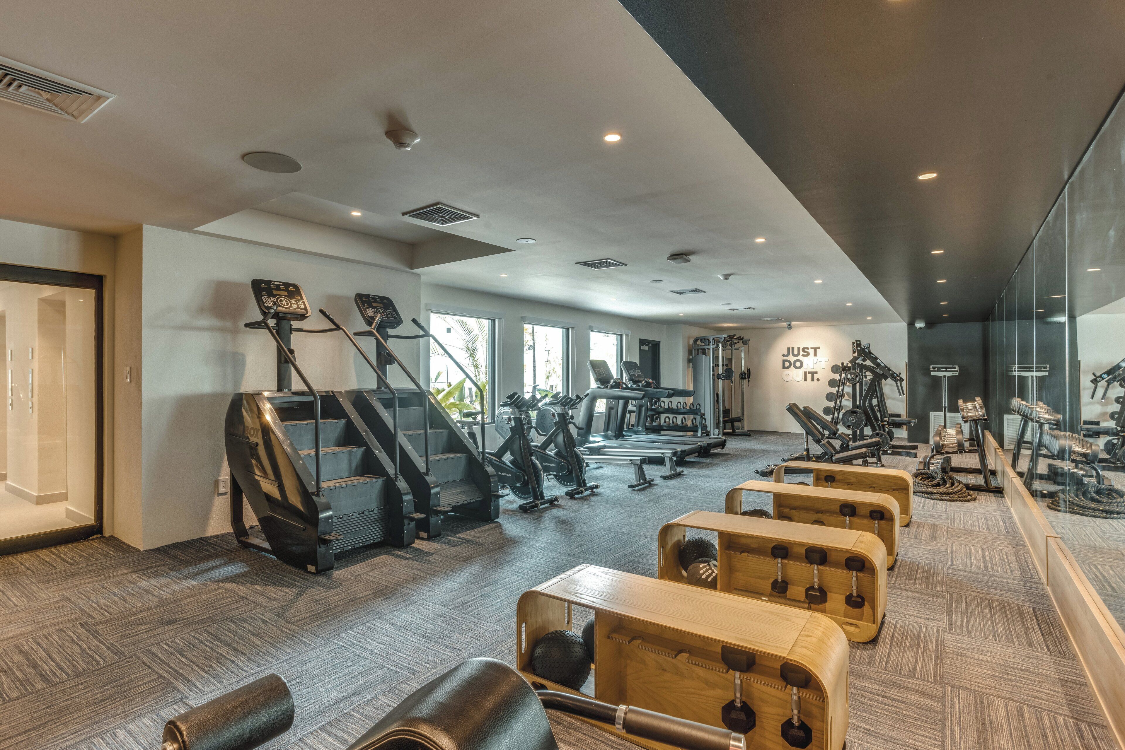 Et moderne fitnesscenter med løbebånd, crosstrainere og vægttræningsområde.
