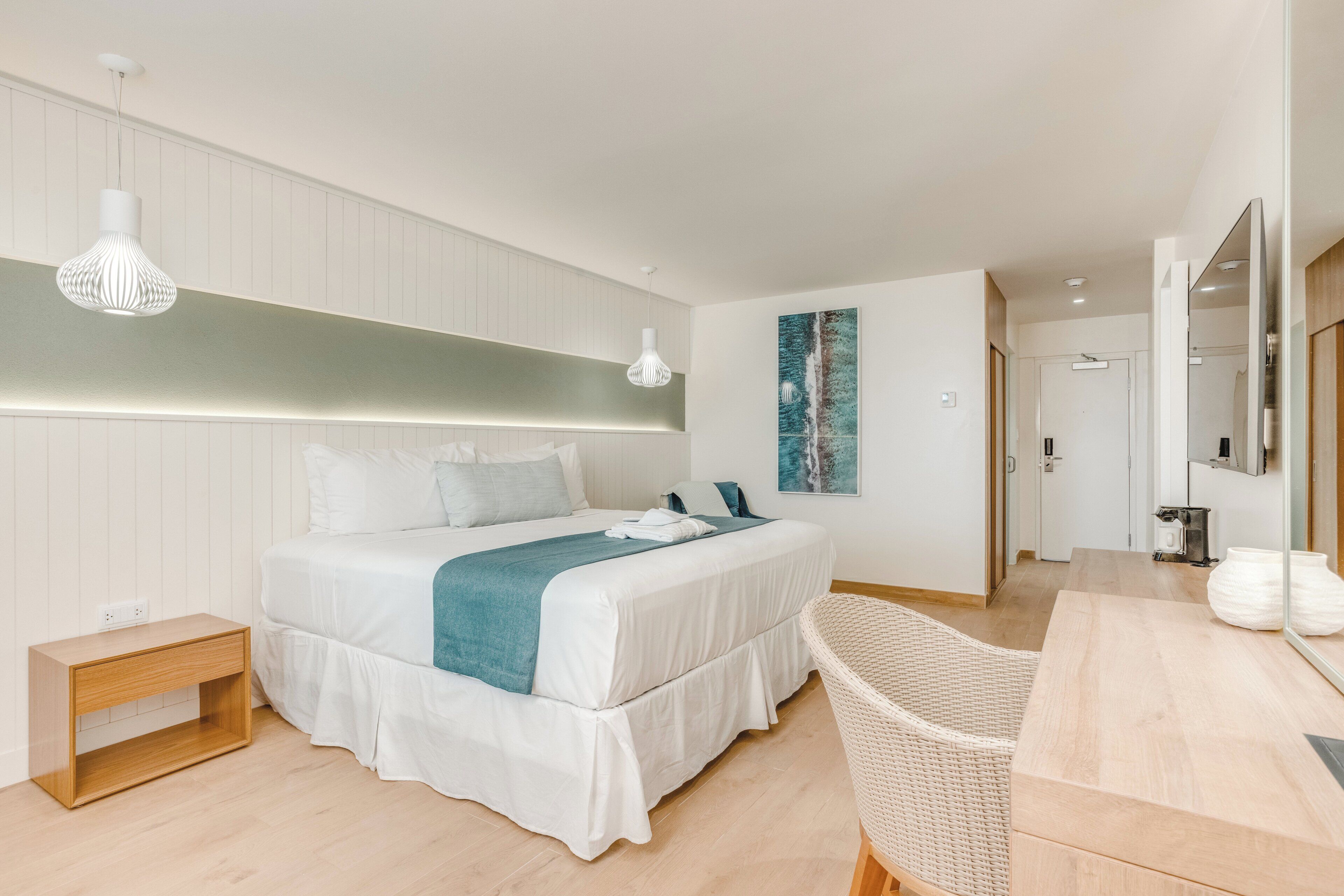 Un dormitorio moderno con cama, mesita de noche y una silla.
