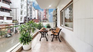 Un balcone con un tavolo, due sedie e piante in vaso.